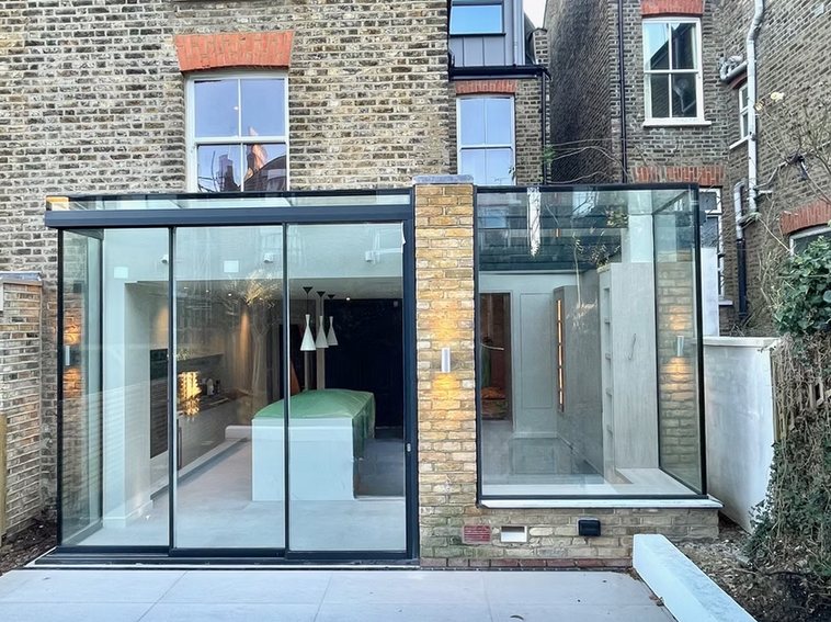 Vaulted open-plan kitchen and dining room with linear lighting and herringbone flooring