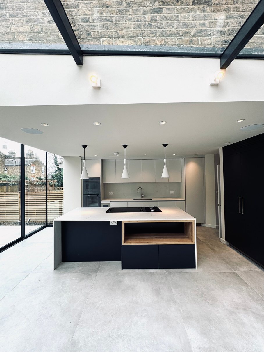 Contemporary kitchen extension with marble island, glazed roof and herringbone floor by Henley Build