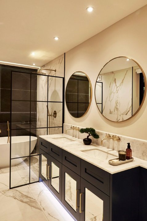 Marble ensuite with twin round mirrors and a walk-in shower