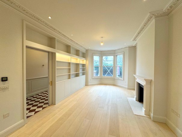 Elegant reception room with fireplace, shutters and herringbone floor
