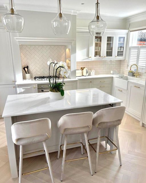 Classic white kitchen with marble island and pendant lighting